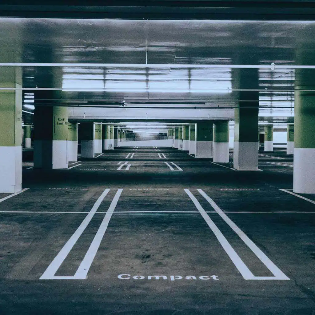 Grey hatchback parked in a well-marked underground California parking lot showing clear restriping benefits