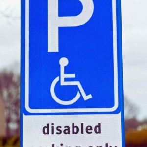 Blue and white disabled parking sign with wheelchair symbol and “disabled” text, illustrating proper ADA-compliant signage used in California parking lots.