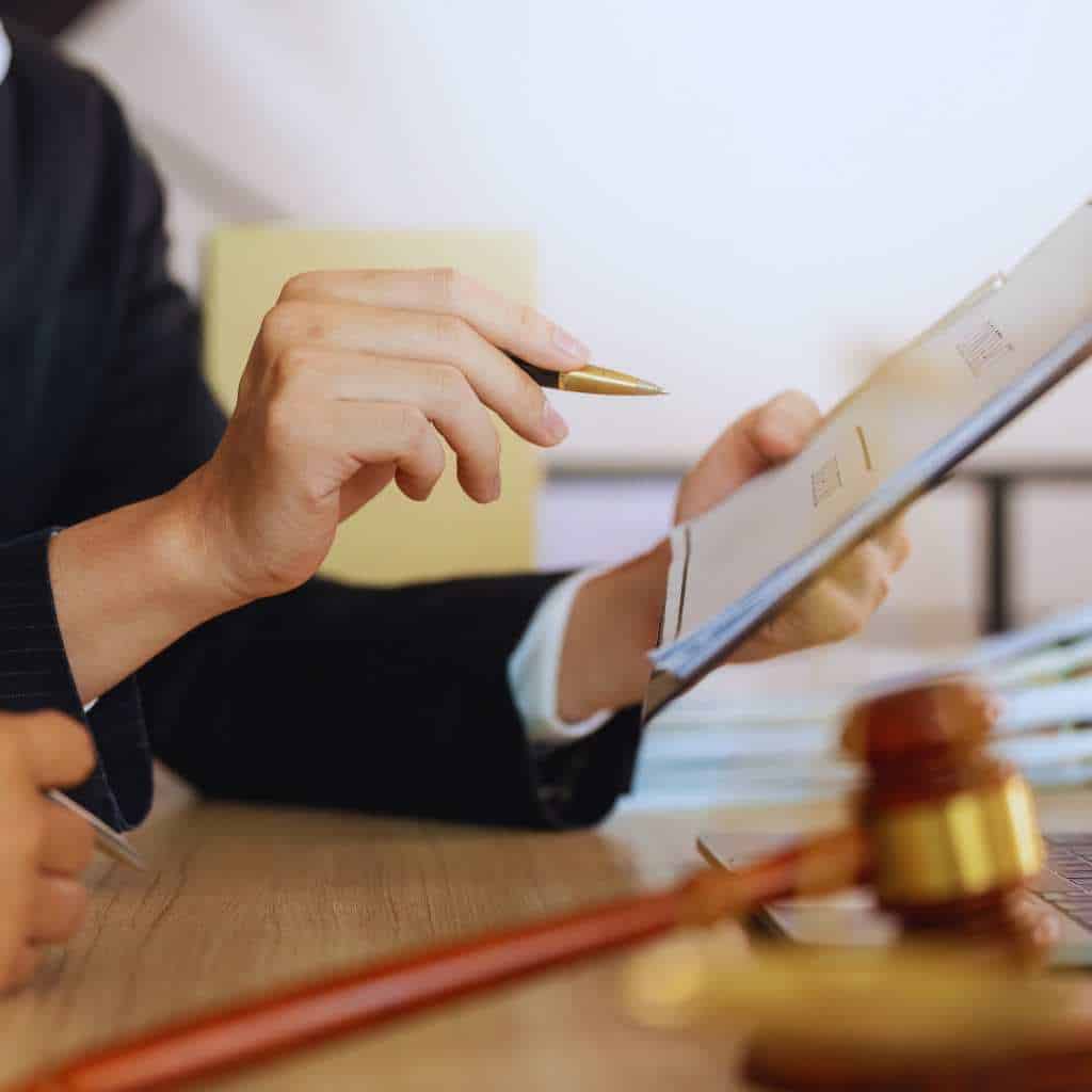 Attorney reviewing building compliance documents with a gavel on the desk, illustrating the legal risks California owners face when elevators do not meet ADA and Title 24 accessibility requirements.